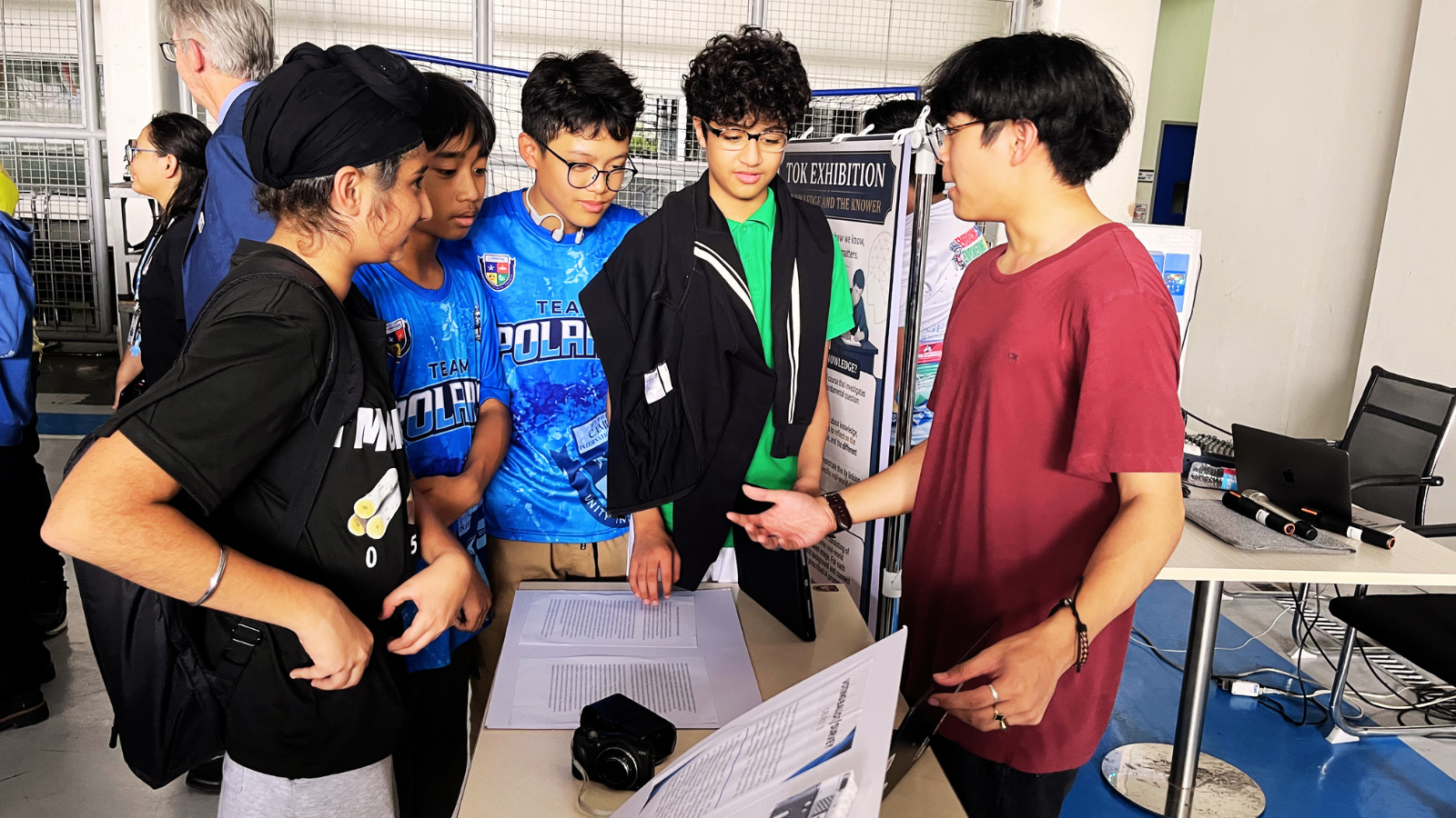  Students engage in academic discussion and peer learning during an exhibition presentation at Philippine Cambridge International School, demonstrating communication, critical thinking, and inquiry skills.