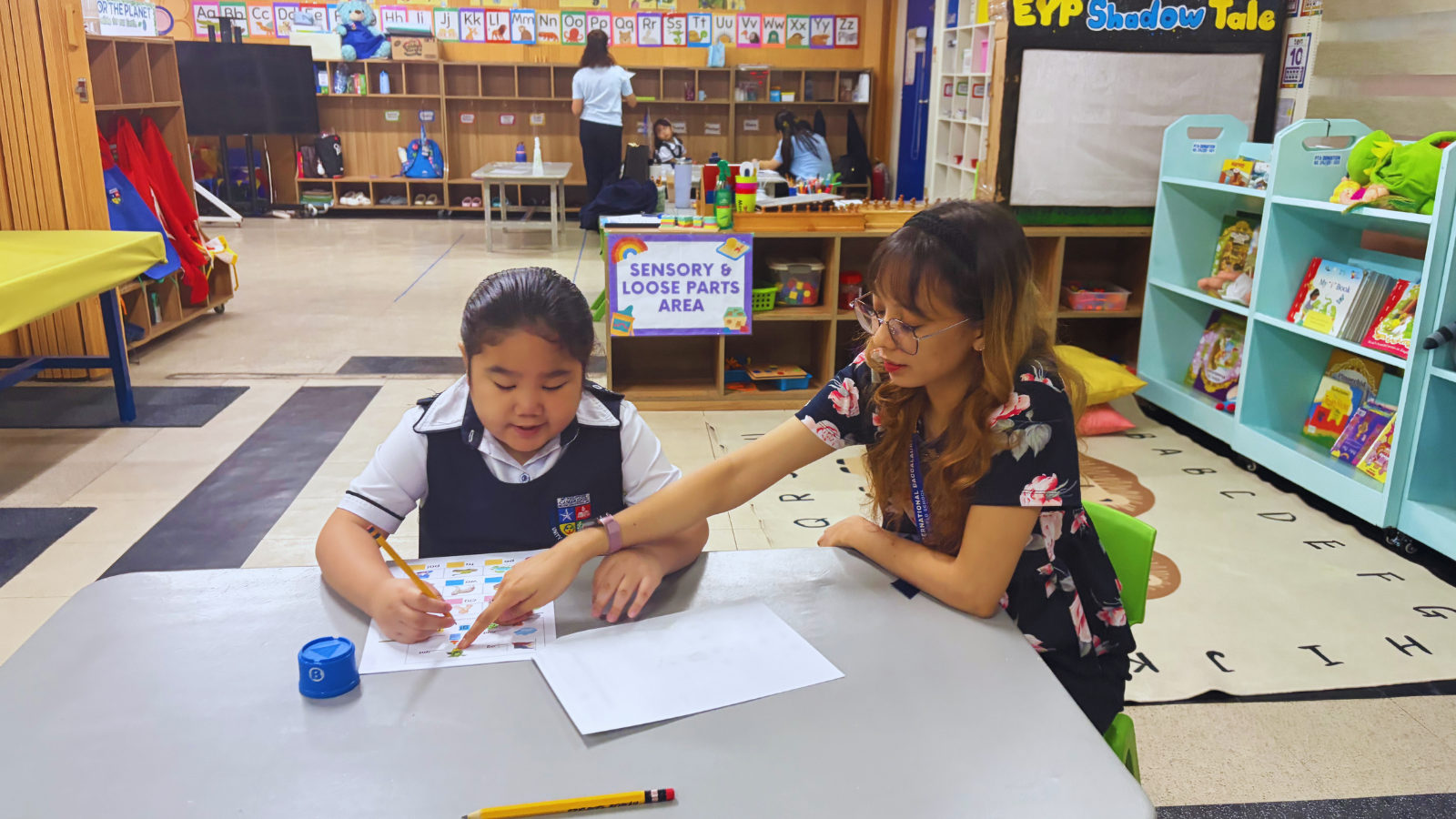 A teacher provides individualized learning support to a young student at Philippine Cambridge International School in Cavite, demonstrating personalized instruction, student-centered education, and the International Baccalaureate (IB) approach in a nurturing classroom that encourages confidence, curiosity, and academic growth.