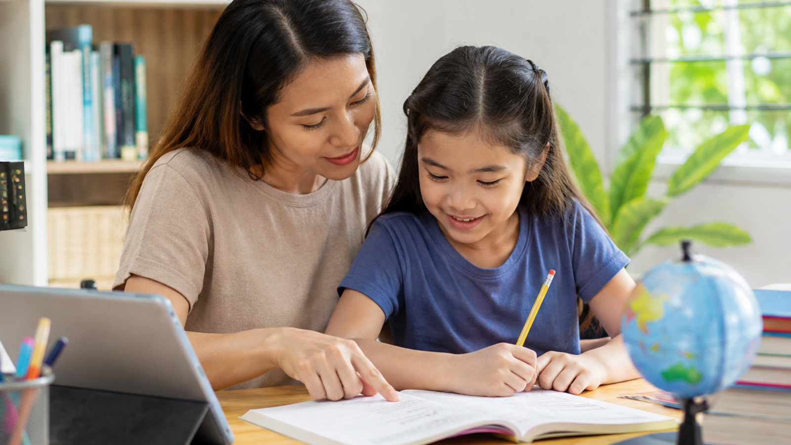 Parent guiding a child during a personalized learning session at home, exploring educational materials together in a supportive learning environment. The image represents homeschooling in the Philippines, family involvement in education, individualized learning pathways, and the importance of choosing the best international homeschool curriculum to support student growth and future success.
