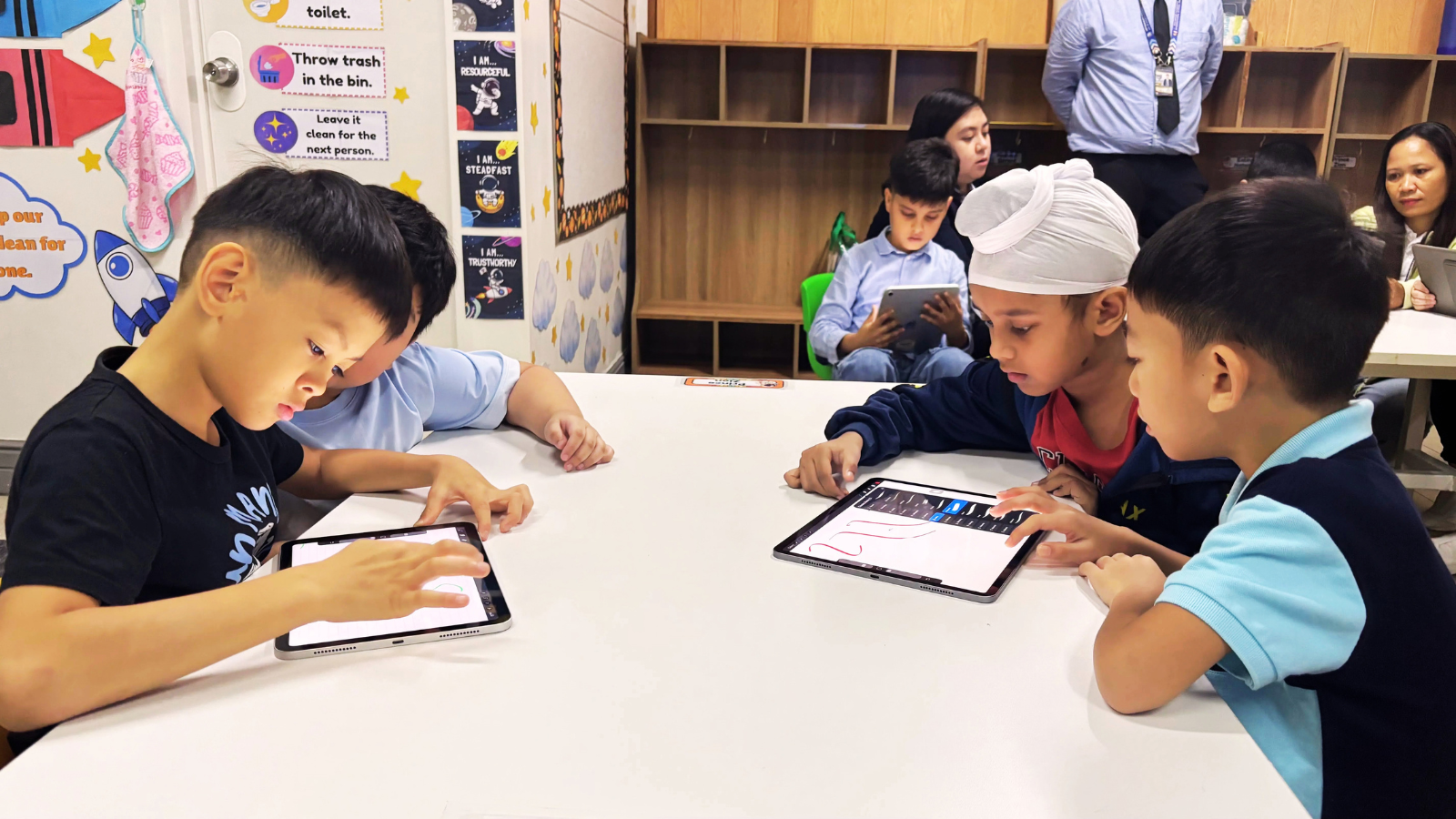 Students at Philippine Cambridge International School in Cavite collaborating on a digital learning activity using tablets in the classroom.
