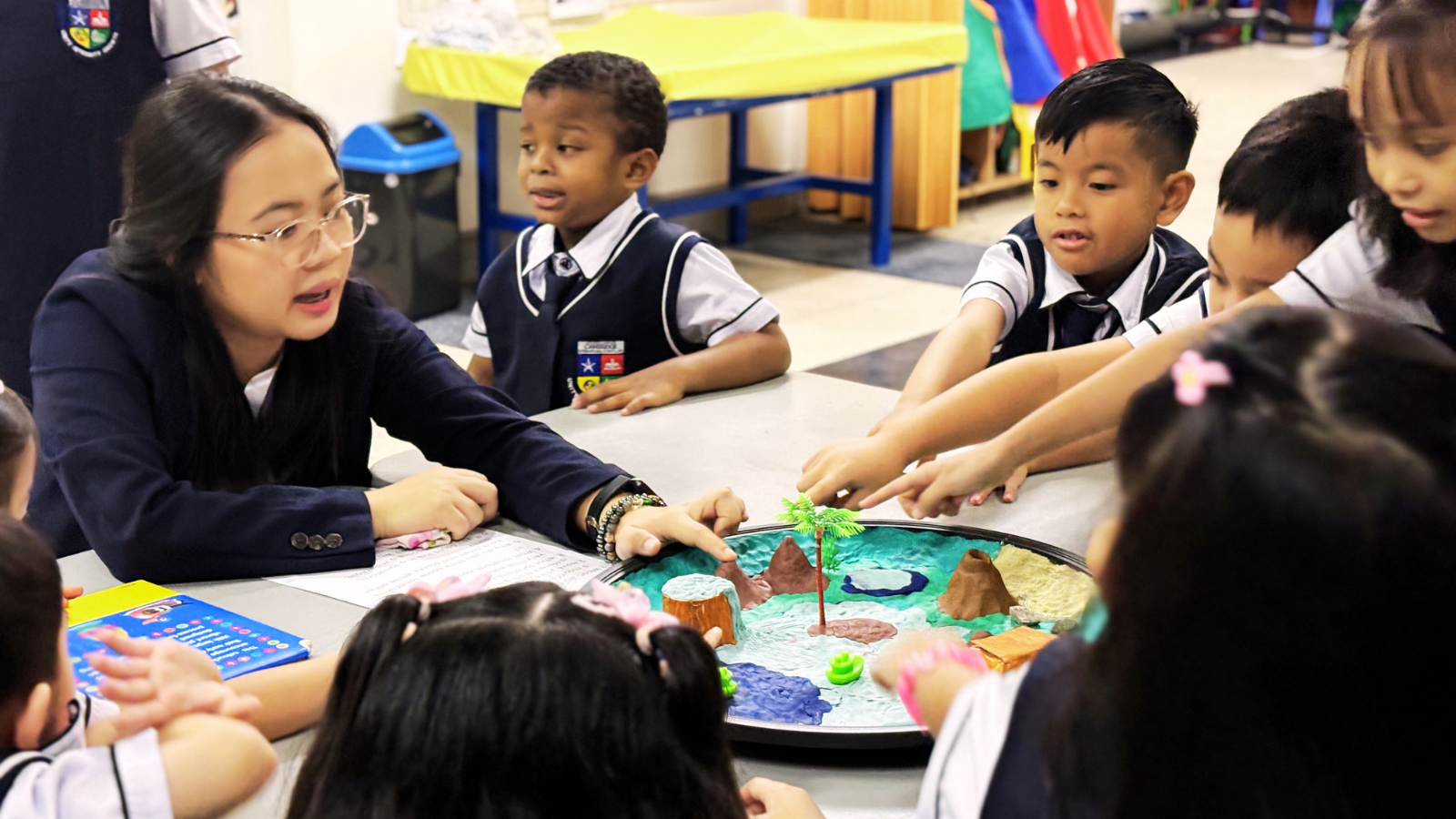 Students at Philippine Cambridge International School in Cavite exploring a hands-on learning activity with their teacher through inquiry and collaboration.