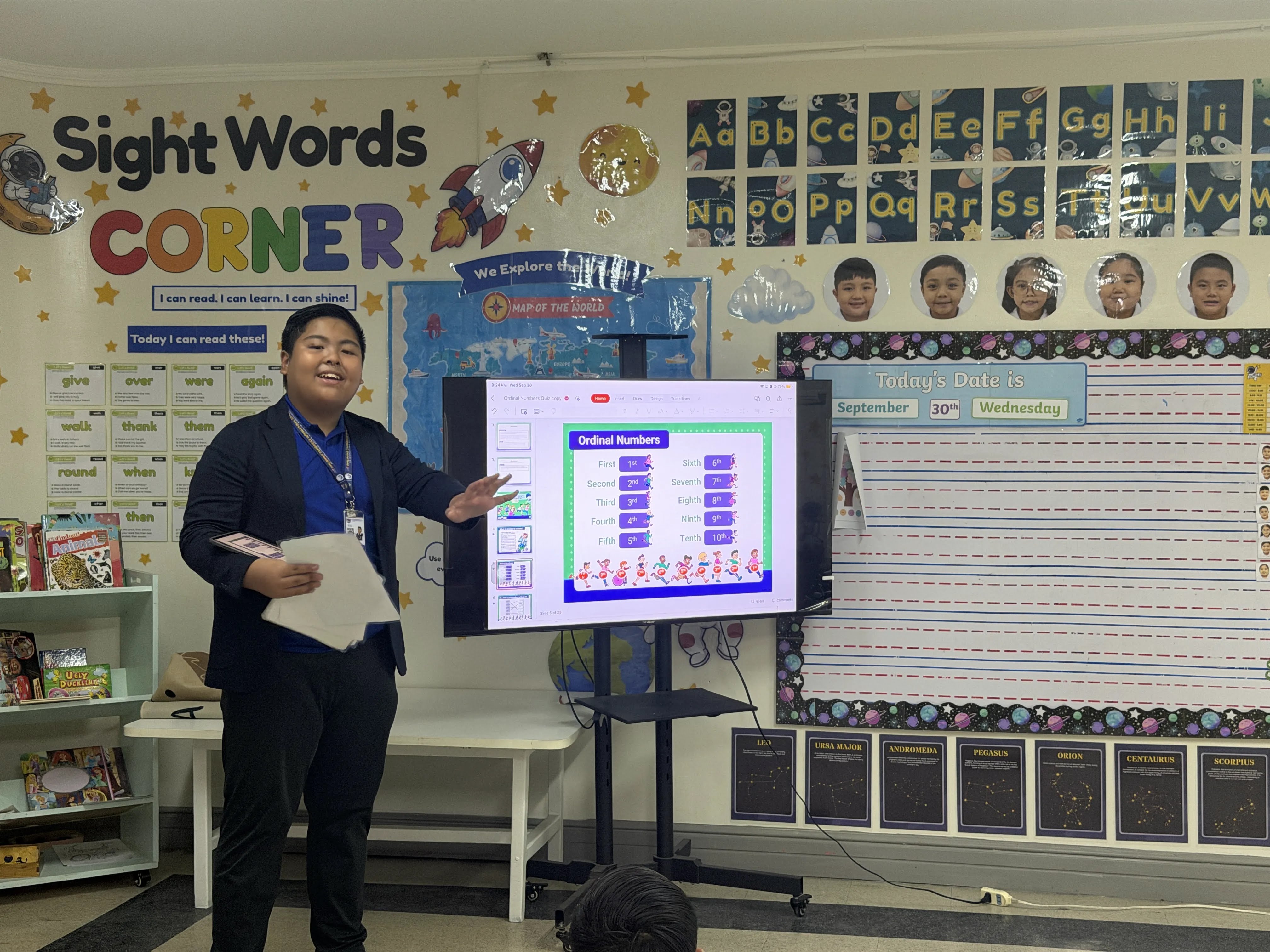 Gab Dela Cruz, MYP 3 learner at Philippine Cambridge International School, teaching a lesson on ordinal numbers to younger students using a classroom presentation during the Teacher-for-a-Day activity. The experience challenged him to prepare learning materials, capture students’ attention, and better understand the patience and effort teachers bring to the classroom.
